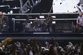 Les frères Gallagher sur scène lors du premier concert d'Oasis depuis 16 ans, vendredi à Cardiff. KEYSTONE/AP/Scott A Garfitt